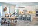 Bright open-concept kitchen with white cabinets, marble countertops, a large island, and stylish dining area at 2124 Clematis Pl, Sarasota, FL 34239