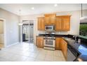 Well-lit kitchen features stainless steel appliances, granite countertops, ample cabinet space, and tile flooring at 234 Padova Way, North Venice, FL 34275