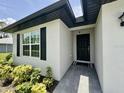 Inviting front entrance with a black door, modern hardware, and tiled walkway at 2425 Maclachlan St, Port Charlotte, FL 33953