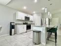 Well-equipped kitchen with stainless steel appliances, a bar, and a modern water dispenser at 2425 Maclachlan St, Port Charlotte, FL 33953