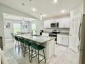 Spacious kitchen featuring a large island, granite countertops, stainless steel appliances, and white cabinets at 2425 Maclachlan St, Port Charlotte, FL 33953