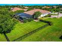 Expansive property featuring a large backyard with a screened-in pool, lush landscaping, and a black metal fence at 336 165Th Ne Ct, Bradenton, FL 34212