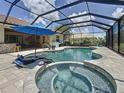 Inviting screened-in pool and spa area with an umbrella and outdoor seating, perfect for relaxation and entertainment at 336 165Th Ne Ct, Bradenton, FL 34212