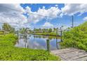 Beautiful waterfront view from the wooden dock, surrounded by lush greenery and serene water reflections at 336 Highland Shores Dr, Ellenton, FL 34222