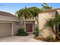 Attractive covered entry with double doors surrounded by lush, mature landscaping at 3658 Torrey Pines Way, Sarasota, FL 34238