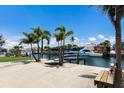 Waterfront property featuring a private boat dock with boats, mature palm trees, and bench at 3715 Bamboo Ter, Bradenton, FL 34210
