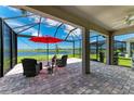 Screened patio featuring brick flooring, comfortable seating, and lake view at 4324 Dairy Ct, Lakewood Ranch, FL 34211