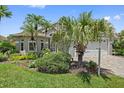 A well-maintained front yard features lush landscaping and palm trees enhancing curb appeal of home at 4330 Beekman Pl # 103, Sarasota, FL 34235