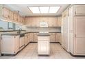 Traditional kitchen features light-colored cabinets, black countertops, a kitchen island, and tile flooring at 4330 Presidential Avenue E Cir, Bradenton, FL 34203