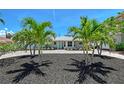 Charming home with a well-manicured front yard and beautiful palm trees for added curb appeal at 444 S Polk Dr, Sarasota, FL 34236