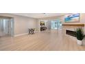 Spacious living room with fireplace, light wood floors, and sliding glass doors to the pool at 444 S Polk Dr, Sarasota, FL 34236