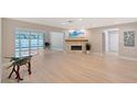 Bright and airy living room with modern fireplace, light wood floors, and pool views at 444 S Polk Dr, Sarasota, FL 34236