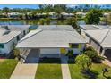 An aerial view of a home with a canal view, white tile roof and vibrant yellow shutters and door at 564 Spanish N Dr, Longboat Key, FL 34228