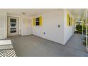 Attached carport with exterior storage; access door and jalousie window with bright yellow trim at 564 Spanish N Dr, Longboat Key, FL 34228