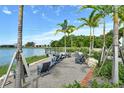 Outdoor sitting area with lake views with comfortable seating and lush landscaping under palm trees at 6204 Isla Del Ray Ave, Sarasota, FL 34240