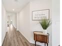 Bright hallway with luxury vinyl plank flooring and a decorative table with ornate plant at 6528 166Th E Pl, Parrish, FL 34219