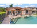 View of the pool and spa, complete with lounge chairs on the brick patio and view of the home's exterior at 7521 Aralia Way, Seminole, FL 33777