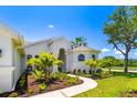 Gorgeous home with a winding sidewalk, mature trees, and beautiful garden at 7727 Heyward Cir, University Park, FL 34201