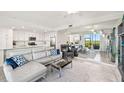 Open-concept living room with view of modern kitchen, and large mirror reflecting water views from sliding glass door at 850 Tidewater Shores Loop # 102, Bradenton, FL 34208