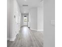 A bright hallway with wood-look floors leads to the front door, showcasing the home's modern design at 8706 Arrow Creek Dr, Parrish, FL 34219