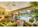Relaxing outdoor patio with comfortable seating, dining area, and a view of the pool and lake at 8717 Misty Creek Dr, Sarasota, FL 34241