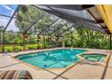 Screened-in pool and spa with lush landscaping, creating a private oasis and beautiful lake views at 8717 Misty Creek Dr, Sarasota, FL 34241