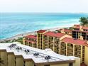 Beachfront condo with a red tile roof, several balconies, and beautiful ocean views in the distance at 8750 Midnight Pass Rd # 501, Sarasota, FL 34242