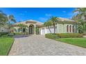 Beautifully landscaped home featuring a three-car garage at 8832 Enclave Ct, Sarasota, FL 34238
