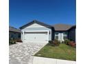 Charming one-story home features a paved driveway, a two-car garage, and beautifully landscaped front yard at 9566 Coastline Way, Parrish, FL 34219