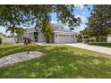 Two-story home showcasing a well-maintained lawn and garden with tropical landscaping, leading to the front entrance at 11839 Shrewsbury Ln, Parrish, FL 34219