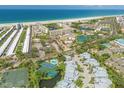 Stunning aerial view of a coastal community with beach access, tennis courts, and multiple swimming pools at 1240 Siesta Bayside Dr # 1240C, Sarasota, FL 34242