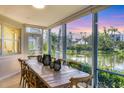 Bright dining area with views of the lush landscape, a serene lake, and ample sunlight at 1240 Siesta Bayside Dr # 1240C, Sarasota, FL 34242