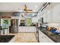 Bright kitchen with white cabinets, granite countertops, stainless steel appliances, and a large window overlooking the yard at 15780 Wilson Rd, Sarasota, FL 34240