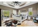 Relaxing primary bedroom features neutral paint, a tray ceiling, a sliding glass door, and an en-suite bathroom at 15780 Wilson Rd, Sarasota, FL 34240