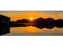 A beautiful sunset view over houses reflecting off the pond creates a relaxing and picturesque community ambiance at 16087 Sunny Day Dr, Bradenton, FL 34211