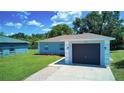 A well-kept single-story home with a gray exterior, a one-car garage, and green lawn at 1707 24Th E St, Palmetto, FL 34221