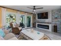 Inviting living room with fireplace, coastal decor, and sliding glass doors to an outdoor patio at 1753 Dawn St # 305, Sarasota, FL 34231