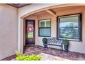 Inviting front porch with a decorative wreath, bench, and colorful brick pavers at 17648 Northwood Pl, Lakewood Ranch, FL 34202