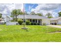 Inviting single-story home with lush green lawn, American flag, and welcoming front porch at 1778 N Salford Blvd, North Port, FL 34286