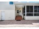 Exterior entryway leading to white door and covered porch with brick steps and landing at 1801 Highland Rd, Osprey, FL 34229