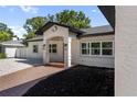 Close up on the main entrance, featuring sconce lighting and brick paver walkway at 1881 Orchid St, Sarasota, FL 34239