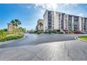 A view of the condominium building with palm trees and well-maintained landscaping at 21405 Olean Blvd # 224, Port Charlotte, FL 33952
