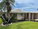 Lovely single-story home featuring lush landscaping, a mature palm tree, and a well-maintained lawn at 3262 Brunswick Ln # 707, Sarasota, FL 34239