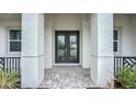 Close up of elegant glass paneled double front doors and walkway with pillars and professional landscaping at 3512 Cross Creek Pkwy, Parrish, FL 34219