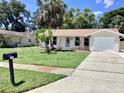 Inviting single-story home with a green lawn and mature trees; a welcoming exterior with a mailbox at 4112 Cochise Ter, Sarasota, FL 34233