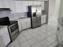 Bright kitchen with stainless steel appliances, white cabinets, and tile flooring at 4354 Rock Creek Dr, Port Charlotte, FL 33948