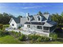Beautiful two-story home with a gray roof, white exterior, a chimney, and a charming front porch at 4888 Old Ranch Rd, Sarasota, FL 34241