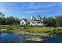 Serene home featuring a pond and a well-kept lawn with mature landscaping at 4888 Old Ranch Rd, Sarasota, FL 34241