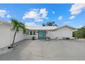 Charming home showcasing a blue entry door, well-manicured landscaping, and a paved driveway at 538 Magellan Dr, Sarasota, FL 34243