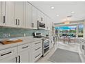 Modern kitchen featuring white cabinets, sleek black hardware, stainless appliances and water-view dining at 538 Magellan Dr, Sarasota, FL 34243